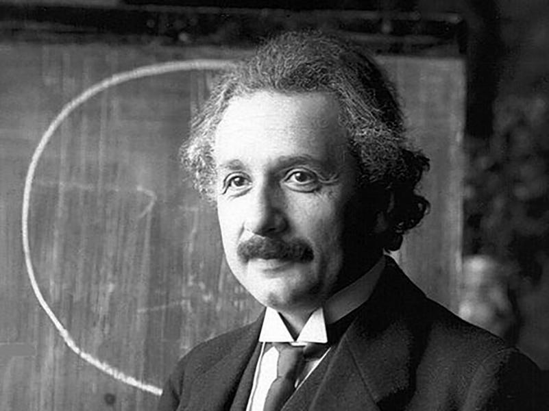 Albert Einstein in front of a blackboard.