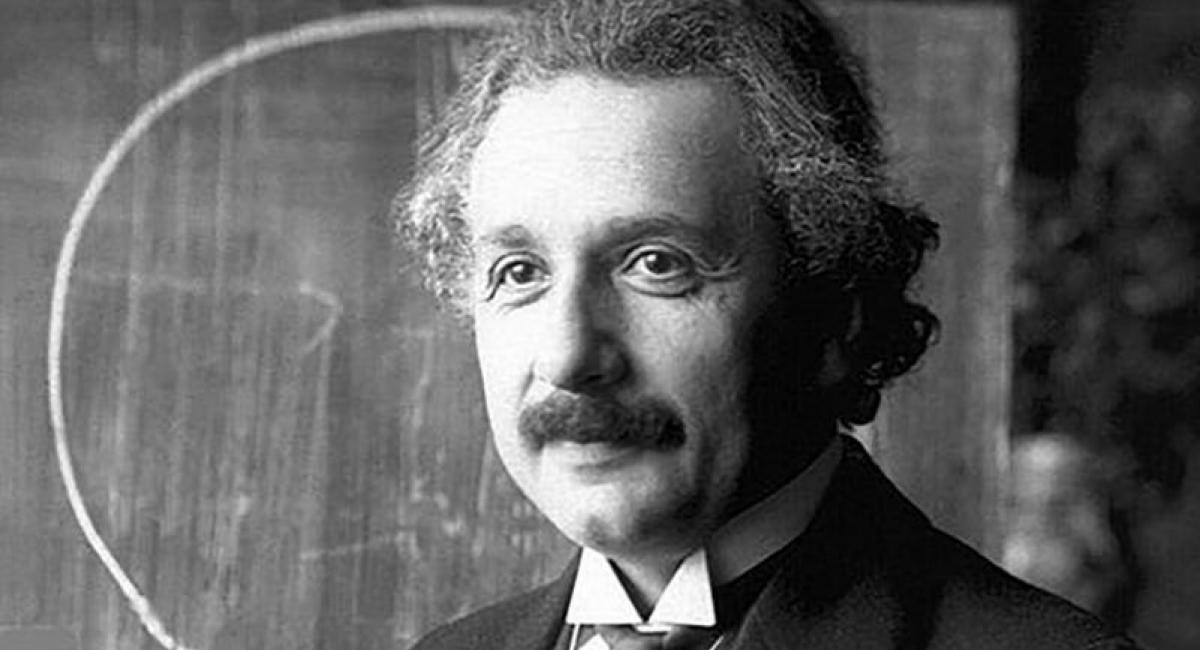 Albert Einstein in front of a blackboard.